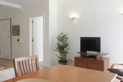 a dining room with a table and a television on a stand at Cosy flat, Salgados Village in Guia