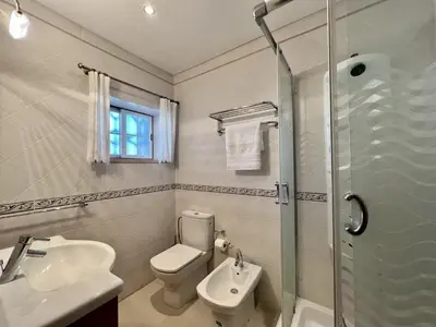 a bathroom with a toilet and a sink and a shower at Quarteira Classic 1 With Pool by Homing in Quarteira