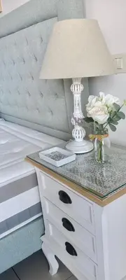 a table with a lamp and flowers on a bed at Quinta da Barracuda Prime Sea View Apartment in Albufeira