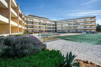 a large building with a garden in front of it at Quinta da Barracuda Prime Sea View Apartment in Albufeira