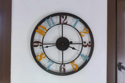 a clock on a wall with an orange and black at CASA NINI - Apart para 6 com AC e a 100 m da praia Mónica Isabel in Albufeira