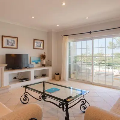 a living room with a glass table and a tv at Apartment Kairi in Vale do Lobo