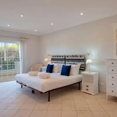 a large bedroom with a large bed with blue pillows at Apartment Kairi in Vale do Lobo