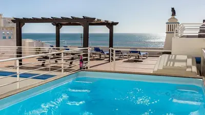a swimming pool on a balcony with the ocean in the background at Refurbished beachfront house, Pool, AC, WiFi, Albufeira, sea view in Albufeira