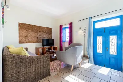 a living room with a couch and a blue door at Refurbished beachfront house, Pool, AC, WiFi, Albufeira, sea view in Albufeira