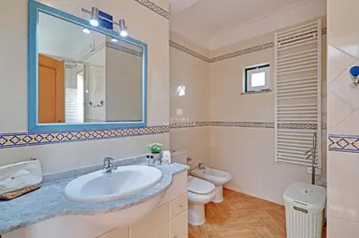 a bathroom with a sink and a toilet and a mirror at Villa Acoteias - By Dalma Portuguesa in Olhos de Água