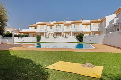 a yellow mat on the grass in front of a building at Villa Acoteias - By Dalma Portuguesa in Olhos de Água