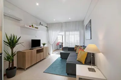 a living room with a couch and a kitchen at Apartamento Peron in Quarteira
