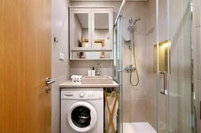 a bathroom with a washing machine and a shower at Apartamento Peron in Quarteira