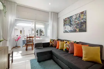 a living room with a couch with colorful pillows at Apartamento Peron in Quarteira