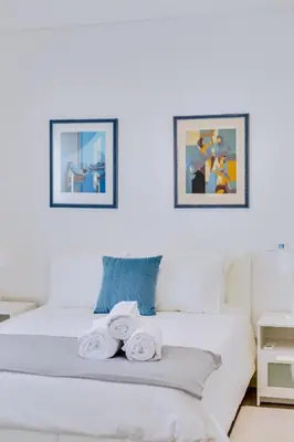 a bedroom with a white bed with towels on it at Marina Star Guesthouse in Faro