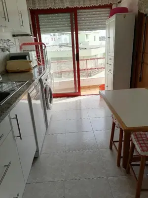 a kitchen with a white refrigerator and a table at Leonel Barcelos in Quarteira