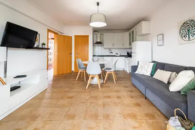 a living room with a couch and a table and a kitchen at BeGuest Copacabana Vilamoura Apartment in Quarteira