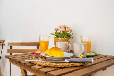 a table with a breakfast of coffee and orange juice at Female Hostel in Faro