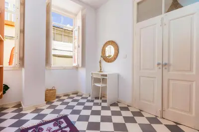 a room with a door and a checkerboard floor at Female Hostel in Faro