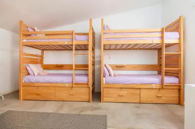 a bedroom with two bunk beds and a rug at Female Hostel in Faro