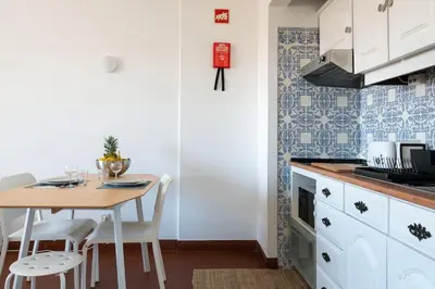 a kitchen with a table and chairs in a room at SILCHORO - Estúdio remodelado com AC e piscina in Albufeira