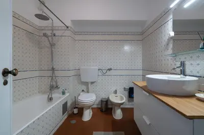 a bathroom with a sink and a toilet and a tub at SILCHORO - Estúdio remodelado com AC e piscina in Albufeira