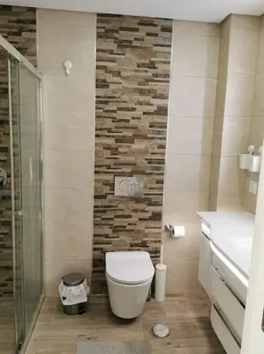 a bathroom with a toilet and a stone wall at Santa Fé in Albufeira