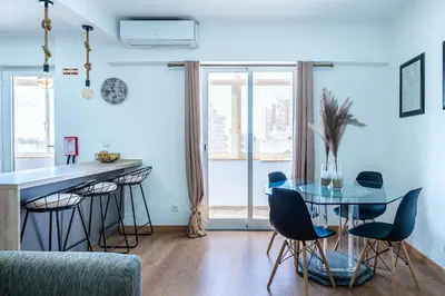 a dining room with a glass table and chairs at Faro Center with AC & WiFi in Faro