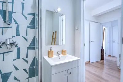 a bathroom with a sink and a glass shower at Faro Center with AC & WiFi in Faro