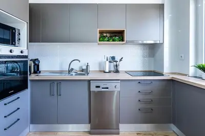 a kitchen with white cabinets and a sink at Faro Center with AC & WiFi in Faro