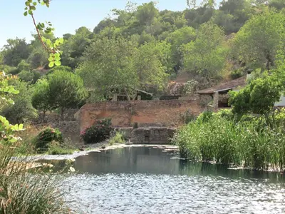 a pond in front of a mountain with a house at Holiday Home Sebastião by Interhome in Paderne