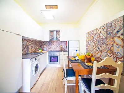 a kitchen with a table and a sink and a dishwasher at Holiday Home Eugênia by Interhome in Paderne