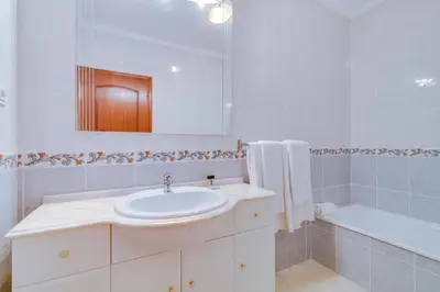 a white bathroom with a sink and a bath tub at AL - Apartamento Pérola in Quarteira