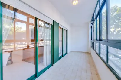 a corridor of a building with glass windows at AL - Apartamento Pérola in Quarteira