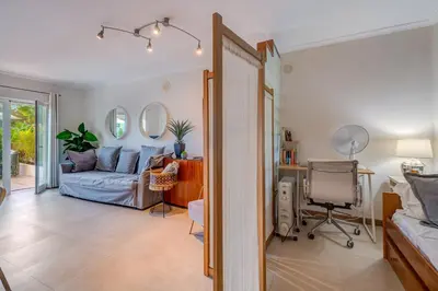 a living room with a couch and a bed and mirrors at Place in the sun - Free out door Jacuzzi - BY BEDZY in Albufeira