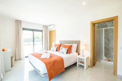 a white bedroom with a bed and a window at Villa Coral Bay by Algarve Vacation in Albufeira