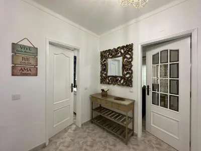 a hallway with white walls and white doors and a mirror at Luxury Villa walking distance Galé Beach Albufeira in Albufeira