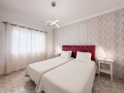 a bedroom with two beds and a red headboard at Luxury Villa walking distance Galé Beach Albufeira in Albufeira
