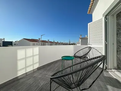 a pair of chairs sitting on a balcony at Luxury Villa walking distance Galé Beach Albufeira in Albufeira