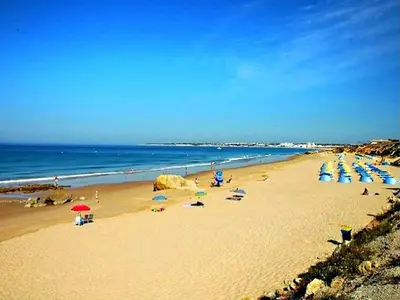 a beach with many umbrellas and people on the beach at Luxury Villa walking distance Galé Beach Albufeira in Albufeira