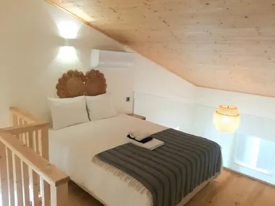 a bedroom with a bed with a black and white blanket at Casa aOrta Studios in Faro