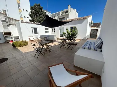 a patio with chairs and tables in a building at Casa aOrta Studios in Faro