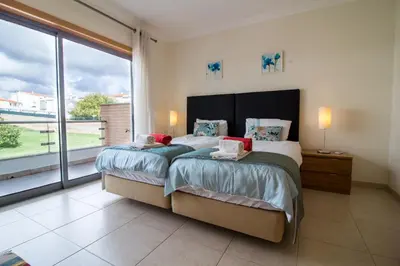 a bedroom with a large bed and a large window at Albufeira Stylish Townhouse in Albufeira