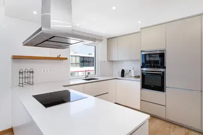 a white kitchen with white cabinets and a sink at Centralgarve - Beachfront with Pool Penthouse in Quarteira