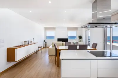 a kitchen and living room with a view of the ocean at Centralgarve - Beachfront with Pool Penthouse in Quarteira