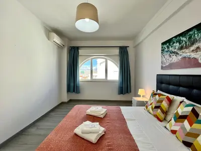 a bedroom with a bed with two towels on it at Albufeira Downtown With Pool by Homing in Albufeira