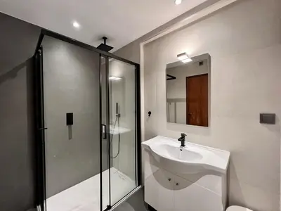 a bathroom with a sink and a glass shower at Albufeira Downtown With Pool by Homing in Albufeira
