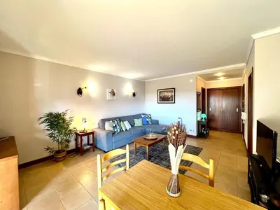 a living room with a blue couch and a table at Albufeira Salgados Beach 3 by Homing in Albufeira