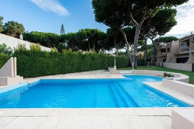 a large blue swimming pool in a yard at ALEGRIA 29 - T2 piso terreo com AC e piscina by My Algarve Rentals in Quarteira