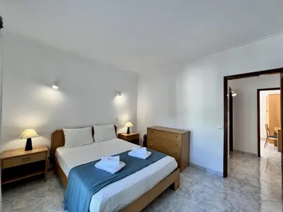 a bedroom with a bed and a dresser and a mirror at Albufeira Falesia Beach 4 by Homing in Albufeira