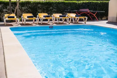 a swimming pool with chairs and a picnic table at Villa Dorado by Algarve Vacation in Albufeira