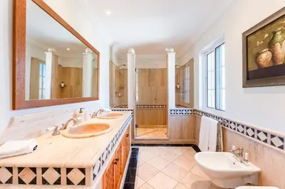 a bathroom with two sinks and a toilet at Villa Breena - Quinta do Mar in Almancil