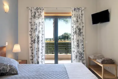 a bedroom with a large bed with blue pillows at Apartamento T1 - Em zona tranquila in Olhos de Água