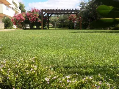 a field of green grass with a gazebo in the background at Marina Vilamoura - Aquamar 006 By Vilamoura Sun in Vilamoura